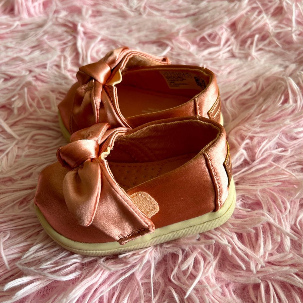 TOMS baby shoes. Gorgeous Rose satin slip ons. Bow Knot design. NEW. SZ 2.